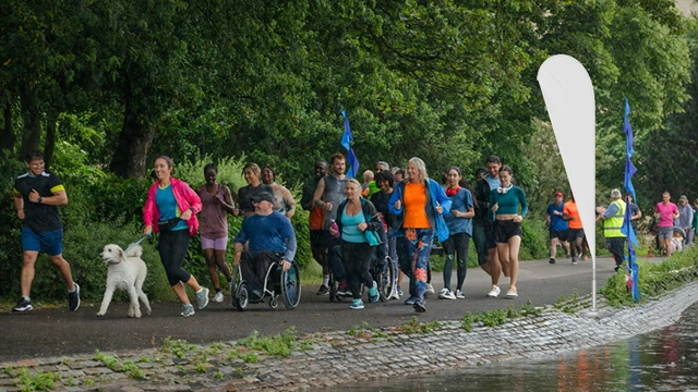 Beachflagg som står på et arrangement, på en gangvei hvor det foregår et maraton